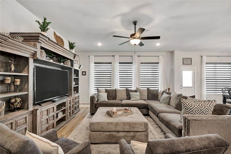 Cozy Living Area - Custom blinds and beautiful natural lighting create a cozy and inviting atmosphere in this family-friendly space.