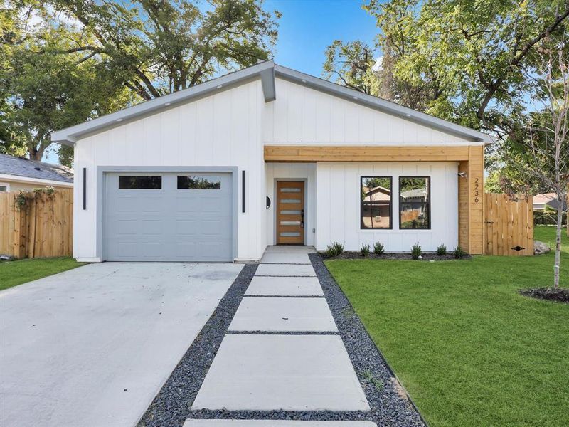 View of front of house featuring a front yard and a garage