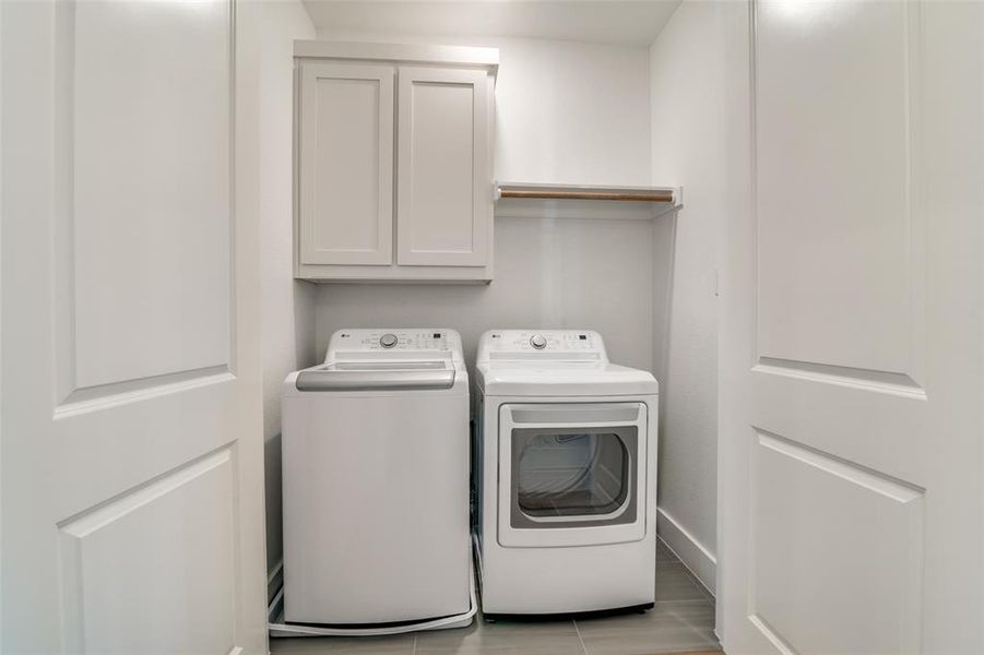 The utility room has a built in storage cabinet and a hanging rack.