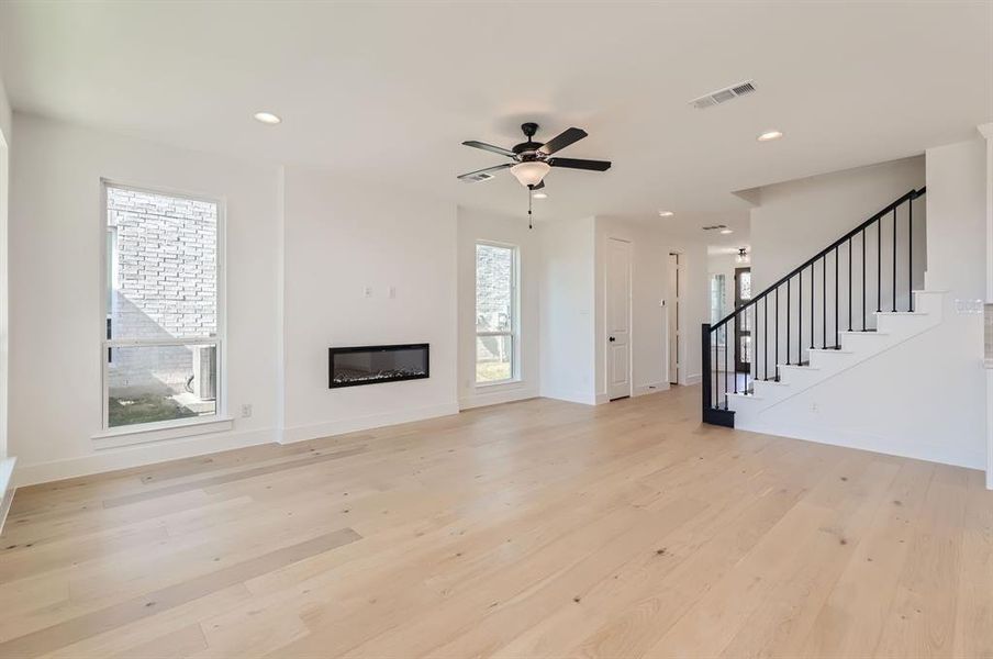 Unfurnished living room featuring ceiling fan, light hardwood / wood-style flooring, and plenty of natural light