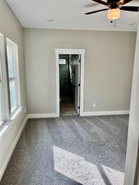 Carpeted spare room with ceiling fan