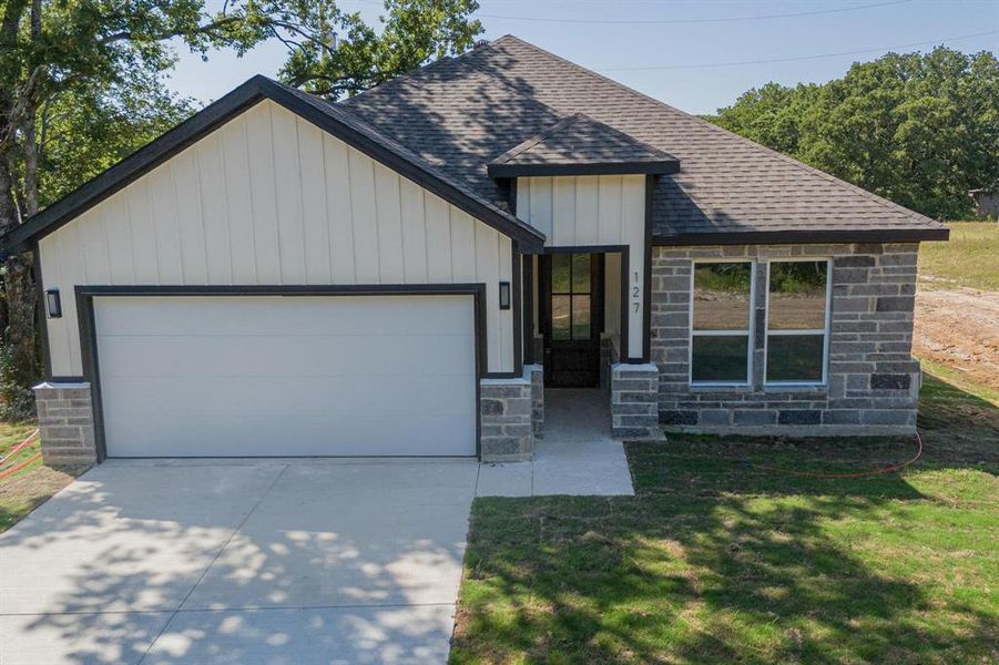 View of front of property featuring a garage and a front yard