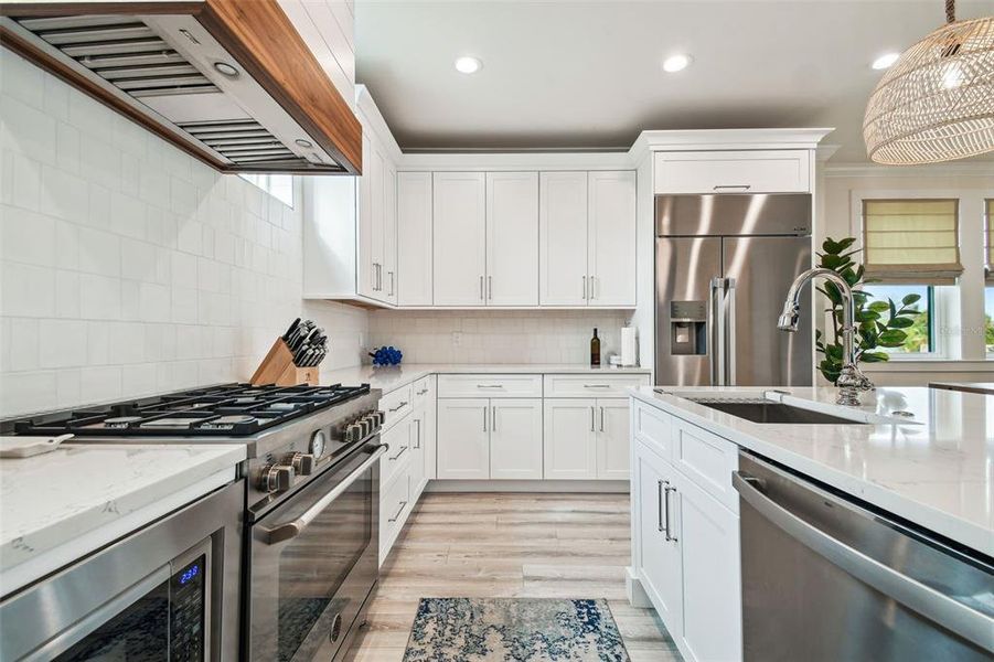 Gas cooktop and custom hood. Tons of cabinets for kitchen storage!