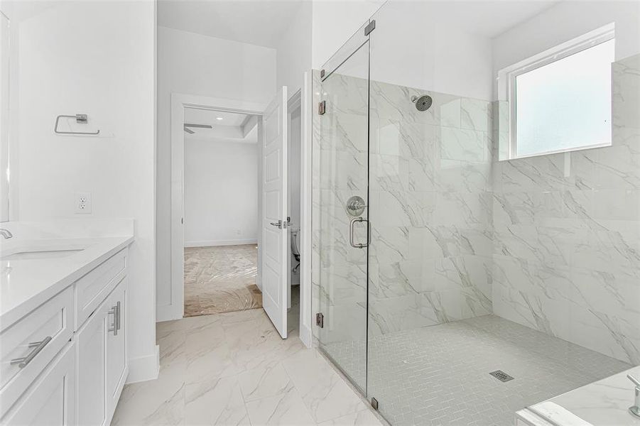 Bathroom featuring a shower with door, vanity, and tile patterned flooring