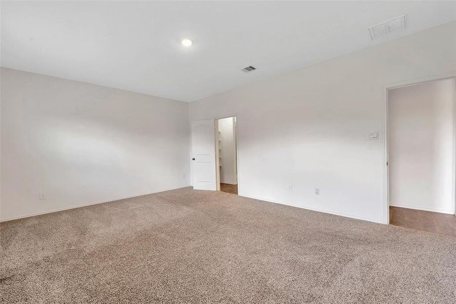 The door to the right leads you from the living room through a hallway into the spacious primary suite. The door to the left takes you to the primary bath and closet.