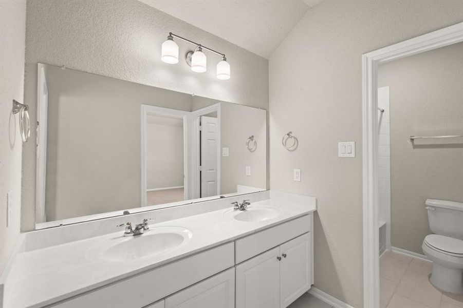 The secondary bath features tile flooring, white cabinetry and light countertops and a shower/tub combo. Perfect for accommodating any visiting family and friends.