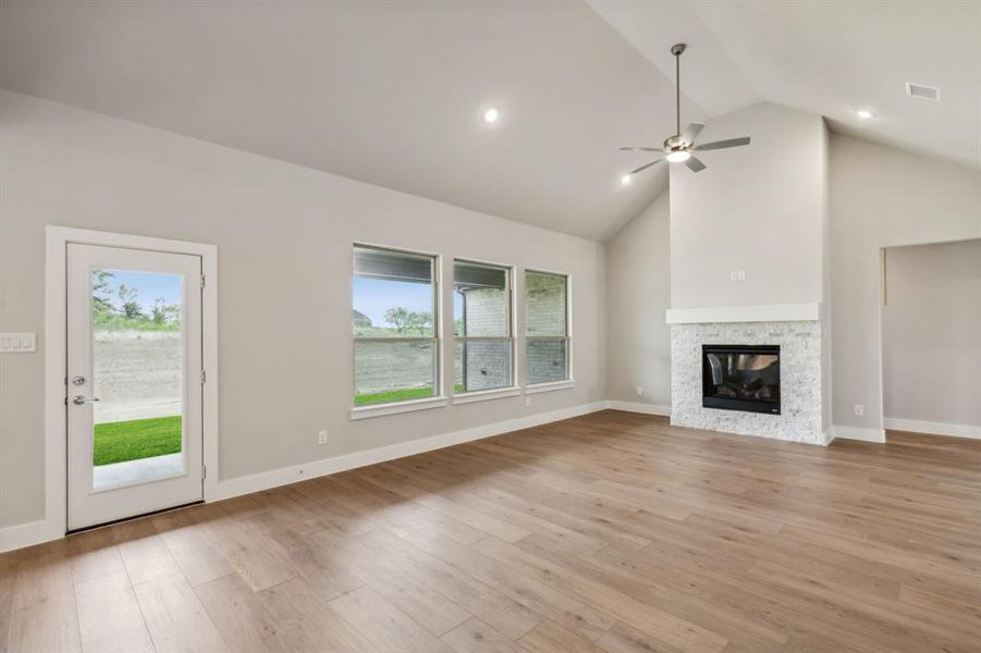 Unfurnished living room featuring light hardwood / wood-style floors, a fireplace, and a wealth of natural light