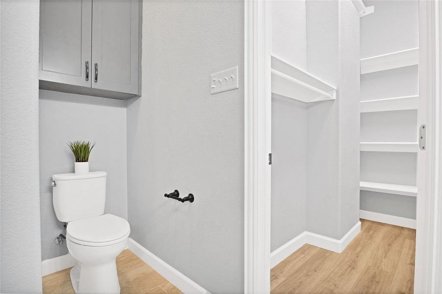 Primary bathroom with walk-in closet and several built-in cabinets for storage space.