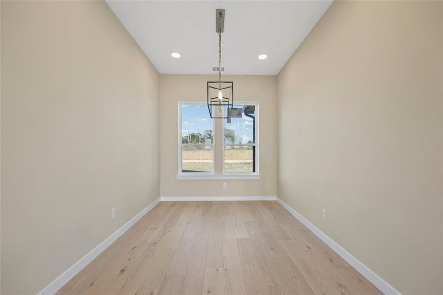 Unfurnished dining area with a notable chandelier and light wood-type flooring