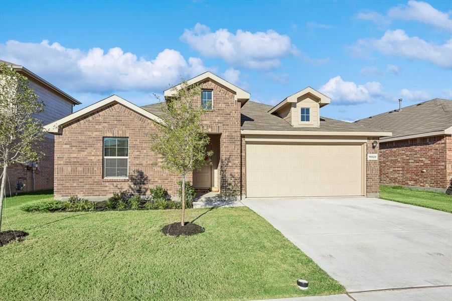 View of front of home with a front yard and a garage