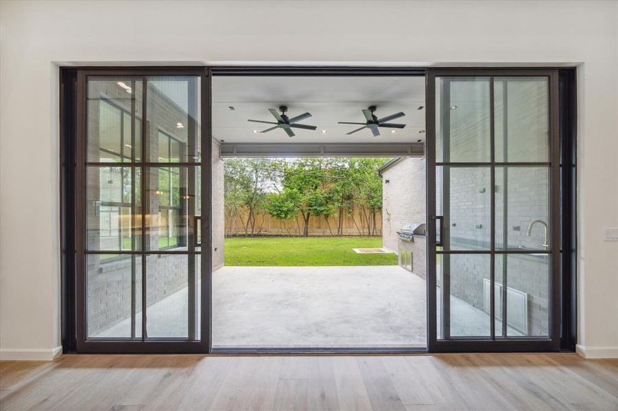 The living room’s large glass doors open up to a covered patio and lush backyard, creating an indoor-outdoor flow perfect for entertaining or relaxing in the privacy of your home.