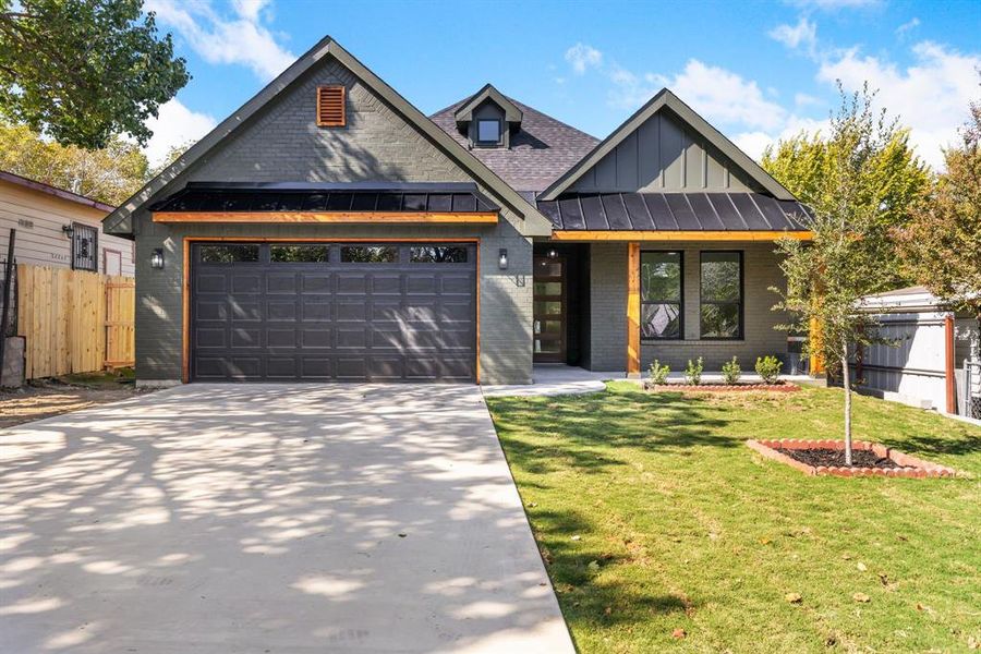 View of front of home with a front lawn and a garage