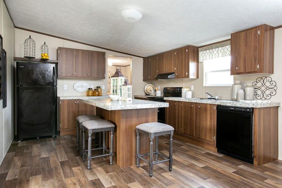 Kitchen featuring lofted ceiling, black appliances, dark wood-type flooring, and extractor fan