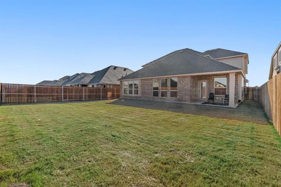 Back of property featuring a yard and a patio