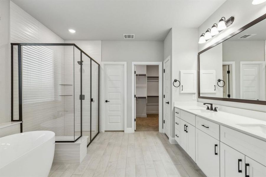 Bathroom with vanity, separate shower and tub, and wood-type flooring