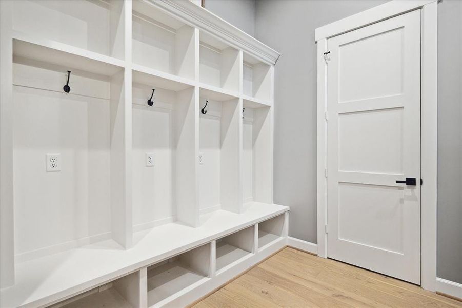 Mudroom with with engineered wood floors, recessed lighting and built-in bench and shelving.