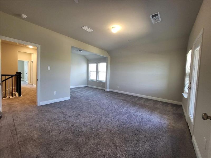 Empty room with lofted ceiling and dark carpet