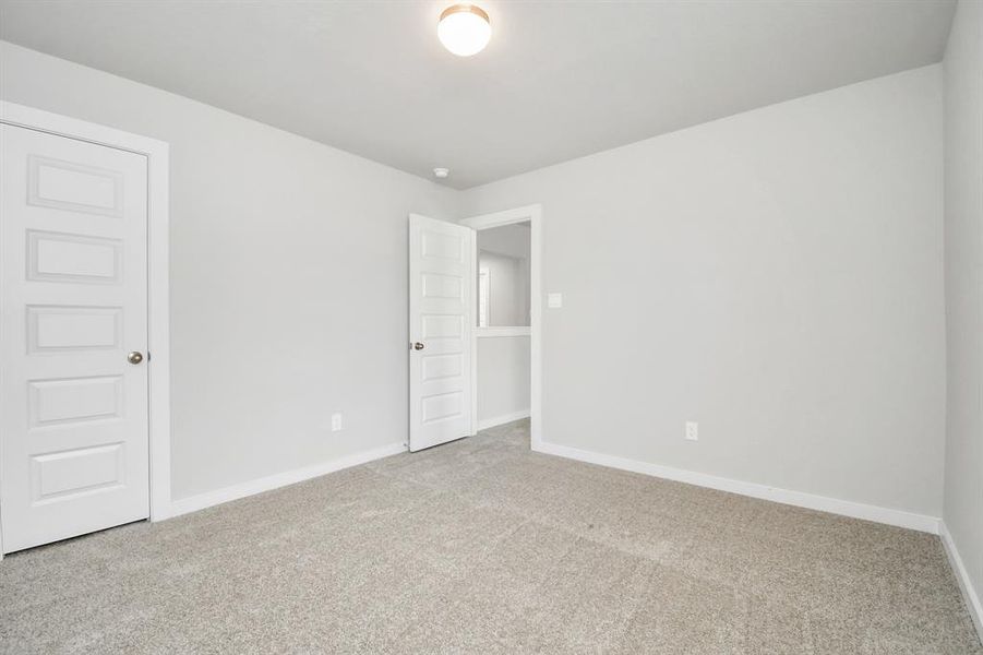 Generously sized secondary bedrooms featuring spacious closets, soft and inviting carpeting underfoot, large windows allowing plenty of natural light, and the added touch of privacy blinds for your personal retreat. Sample photo of completed home with similar floor plan. Actual colors and selections may vary.