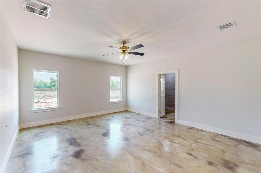 Empty room featuring concrete floors and ceiling fan