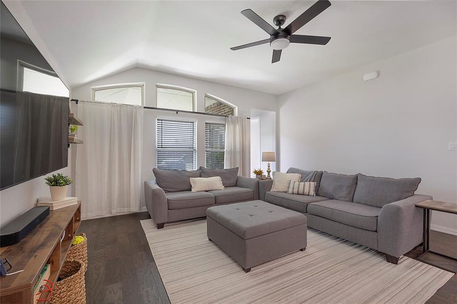 Living room featuring light hardwood / wood-style flooring, lofted ceiling, and ceiling fan