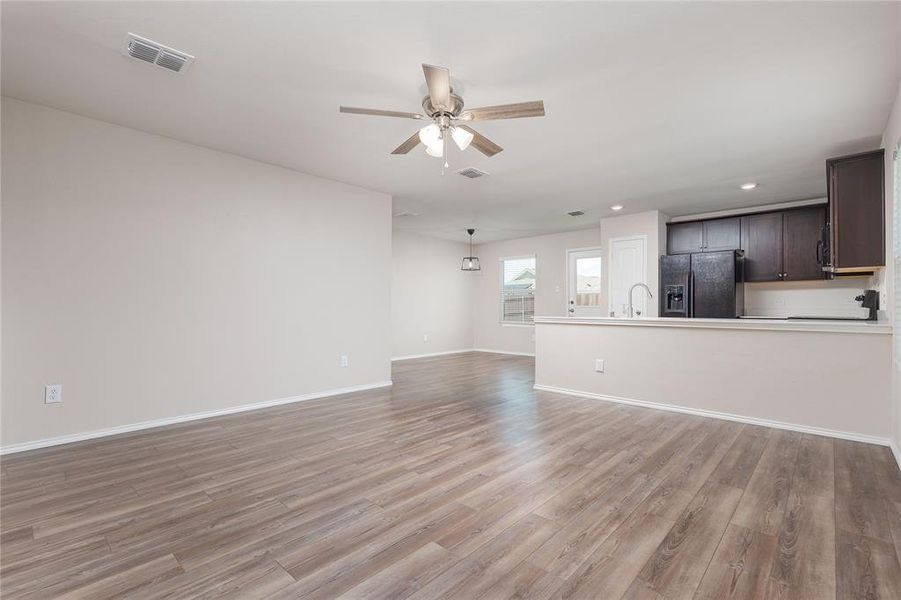 Unfurnished living room with ceiling fan and light wood-type flooring