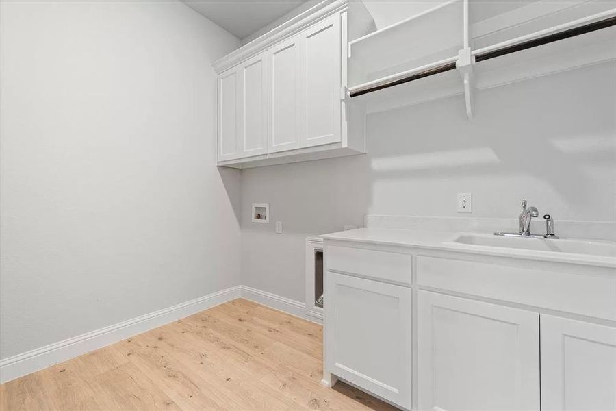 Laundry room with cabinets, sink, light hardwood / wood-style flooring, and hookup for a washing machine