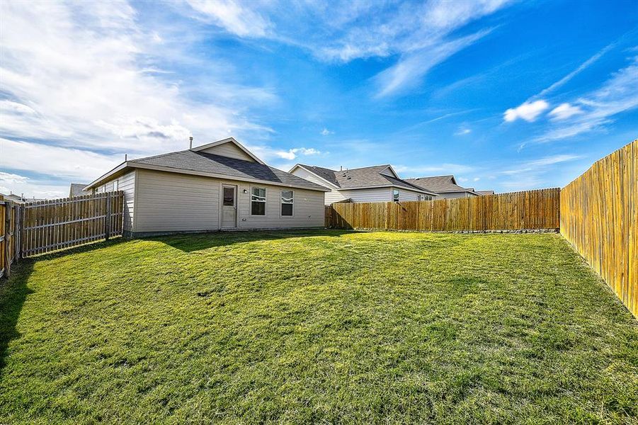 Rear view of property with a lawn