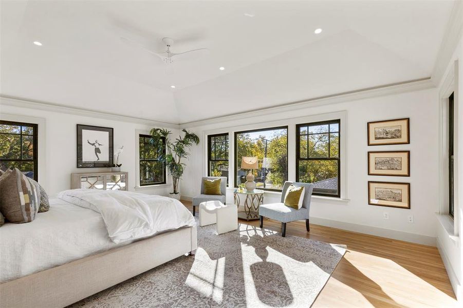 Bedroom with ceiling fan, a tray ceiling, crown molding, hardwood / wood-style floors, and vaulted ceiling