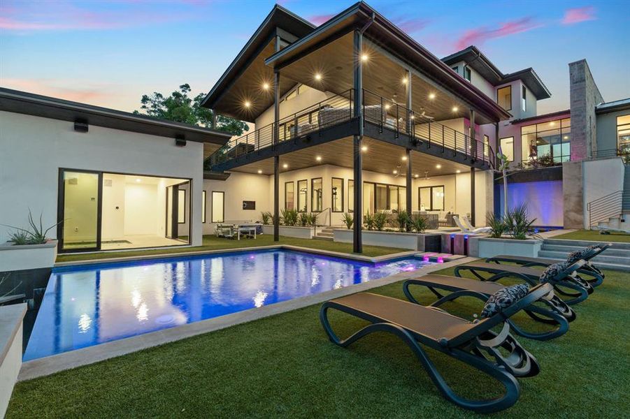 Outdoor living at its finest with a multilevel pool and an indoor/outdoor bathhouse style spa. The dreamy infinity edge pool is surrounded in a high-end turf pool deck, and custom LED lighting runs that run up the waterfall.