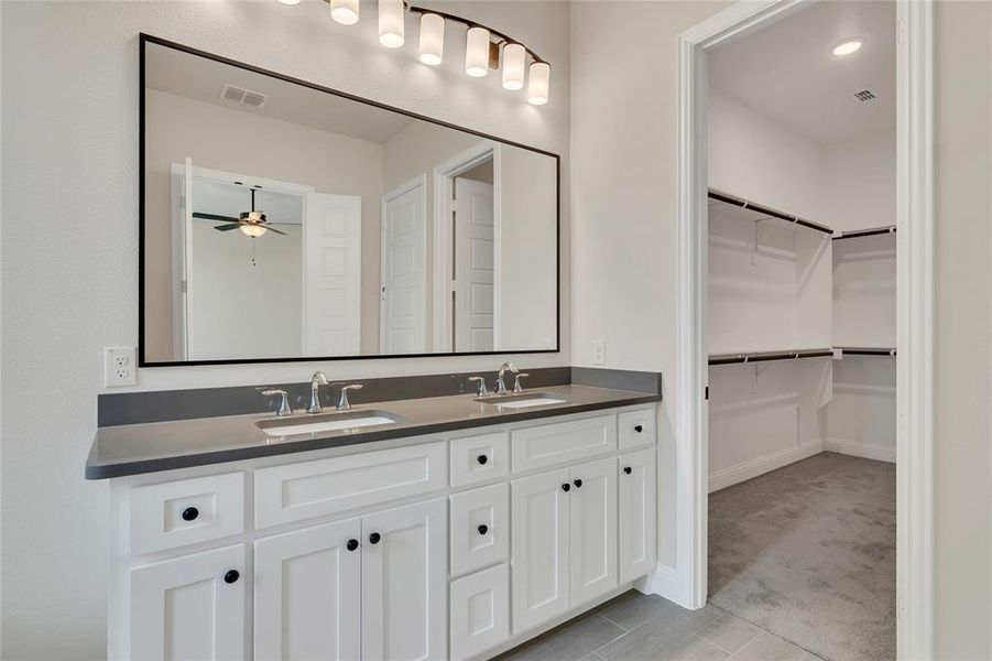 Bathroom featuring double vanity, tile patterned flooring, and ceiling fan