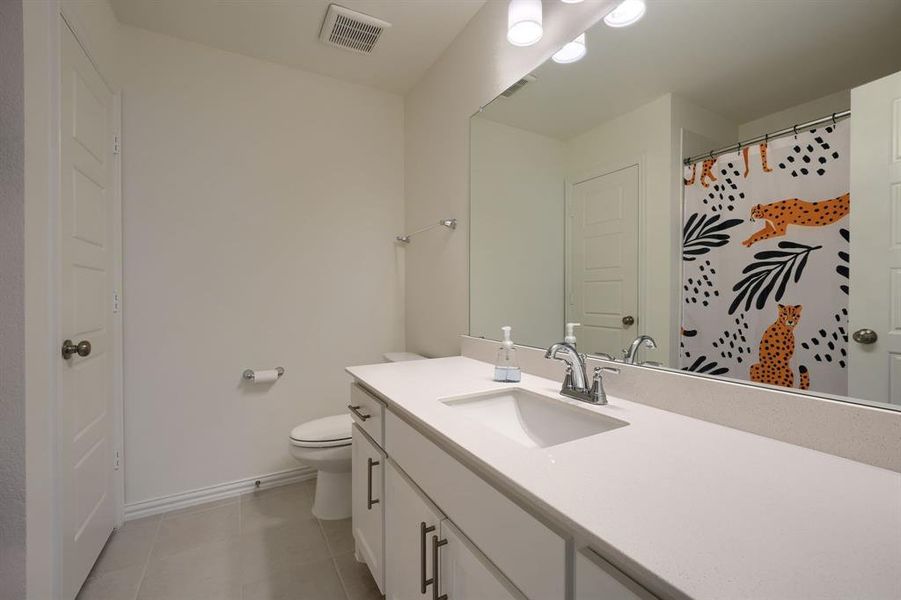 Bathroom featuring tile floors, toilet, and oversized vanity