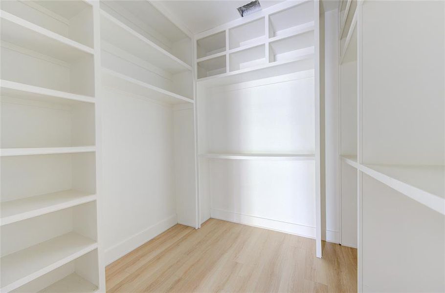 Primary closet includes custom built-ins for lots of storage