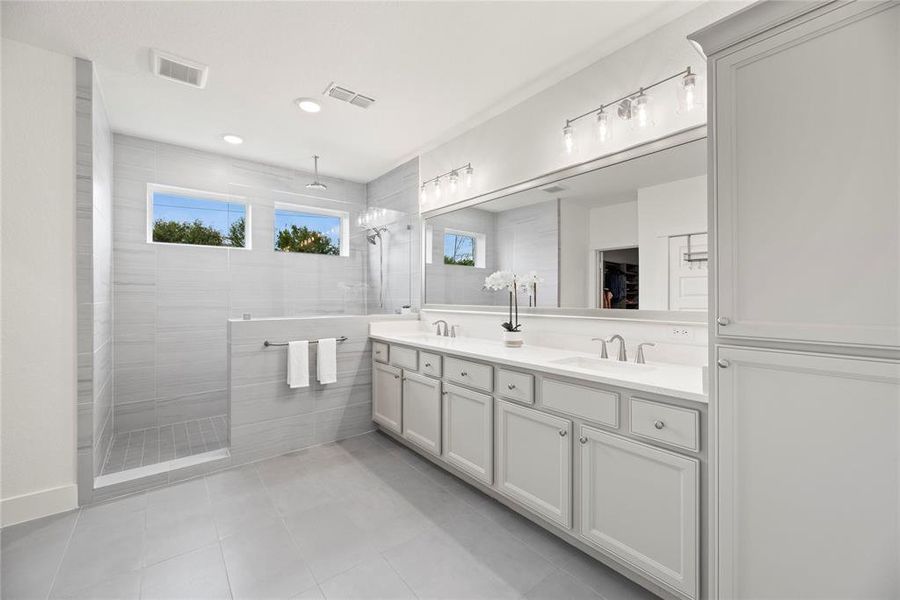 Gorgeous Primary Bath with Fantastic Storage, Dual Sinks, Elegant Lighting, And Walk in Rain Shower