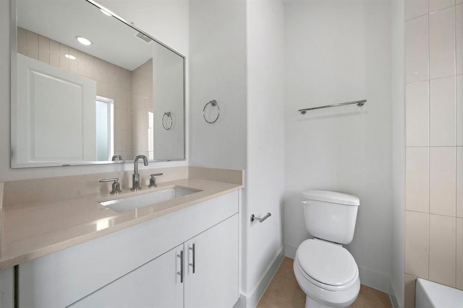 The secondary bedroom has its own private bathroom with beautiful finishes and tile to the ceiling above the shower.