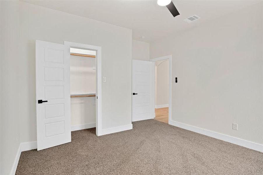 Unfurnished bedroom with a closet, ceiling fan, and carpet