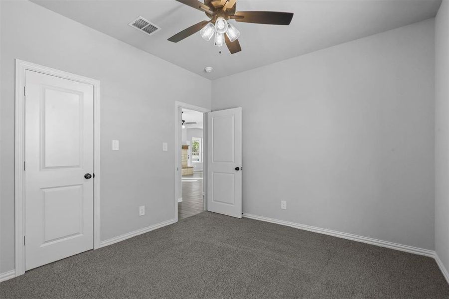 Unfurnished bedroom featuring ceiling fan and carpet floors