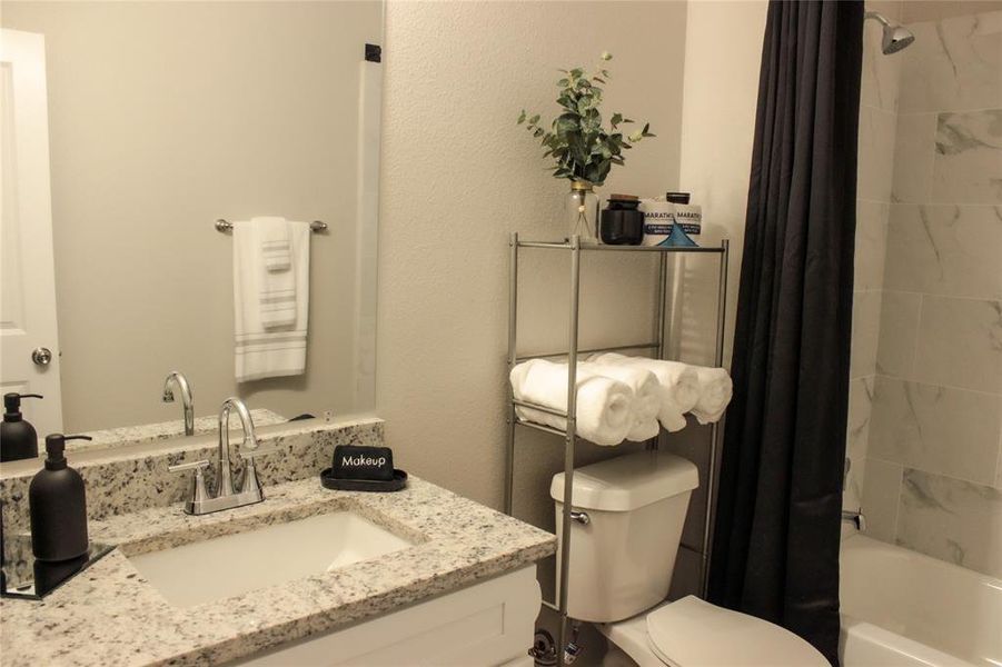 Full bathroom featuring vanity, toilet, and shower / bath combo with shower curtain