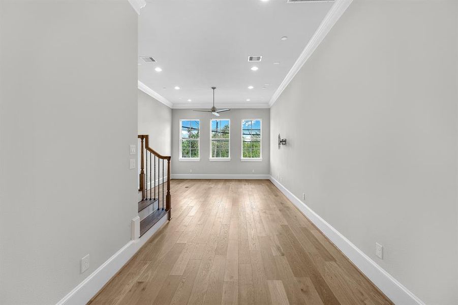 With its high ceilings, thick baseboards, and elegant crown molding, the dining room exudes sophistication. Recessed lighting enhances the ambiance, making it a perfect spot for both casual meals and special gatherings.