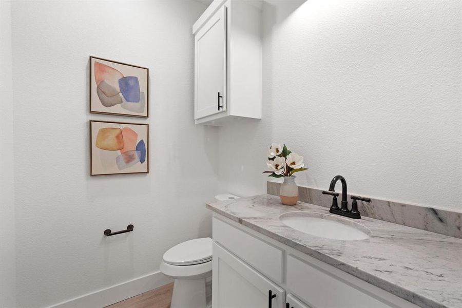 Bathroom featuring hardwood / wood-style flooring, vanity, and toilet