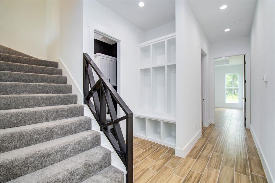 Stair access to game or man cave room with a mud room