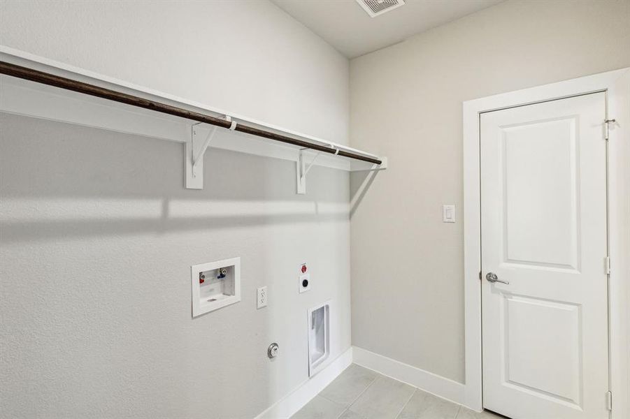 Laundry area featuring washer hookup, gas dryer hookup, light tile patterned floors, and hookup for an electric dryer