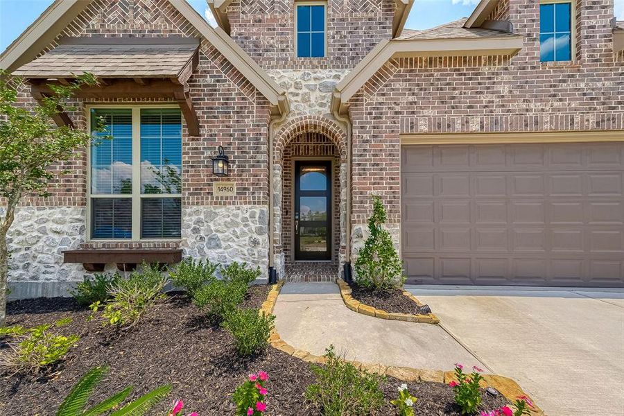 Stately brick & stone interior home already includes landscaping, plantar window box to plant flowers of your choice. Front porch contains side nooks to hide packages, heightened 2.5-car garage paneling for your taller vehicles. Gorgeous glass craftsmanship on the front door, features opaque glass for privacy.