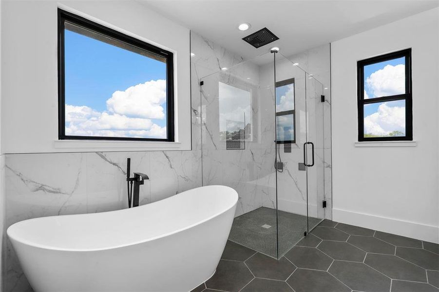 Bathroom with independent shower and bath, tile patterned flooring, and tile walls