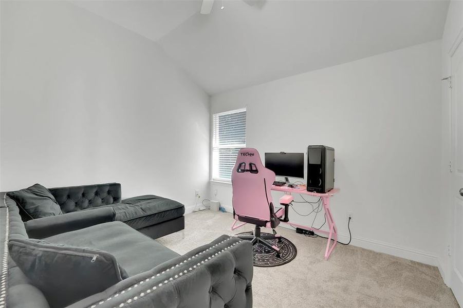 Office space with light colored carpet, ceiling fan, and vaulted ceiling