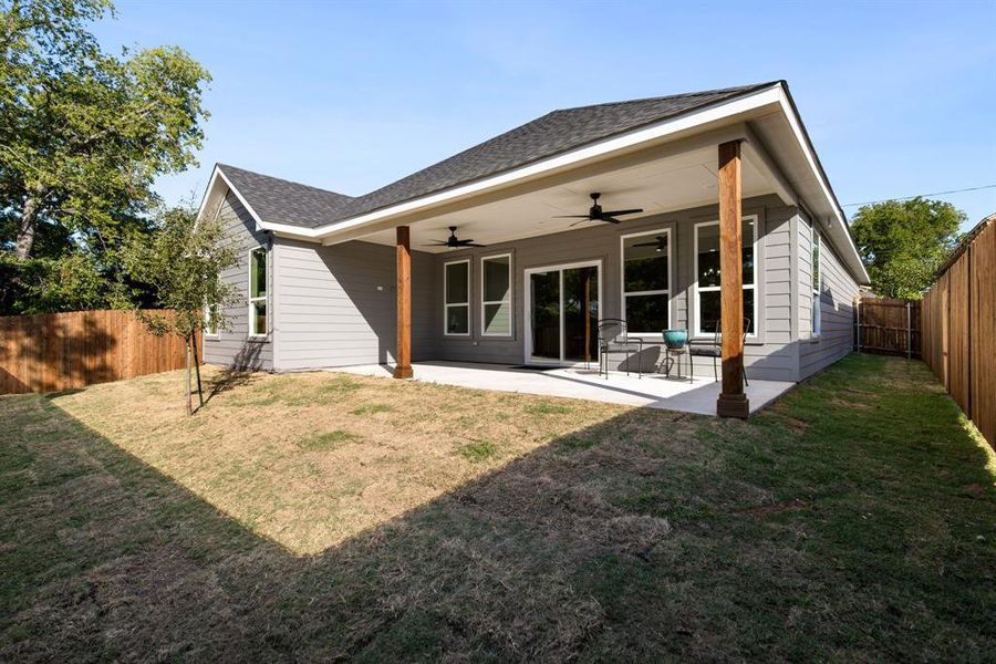 Back of house featuring a yard, ceiling fan, and a patio area