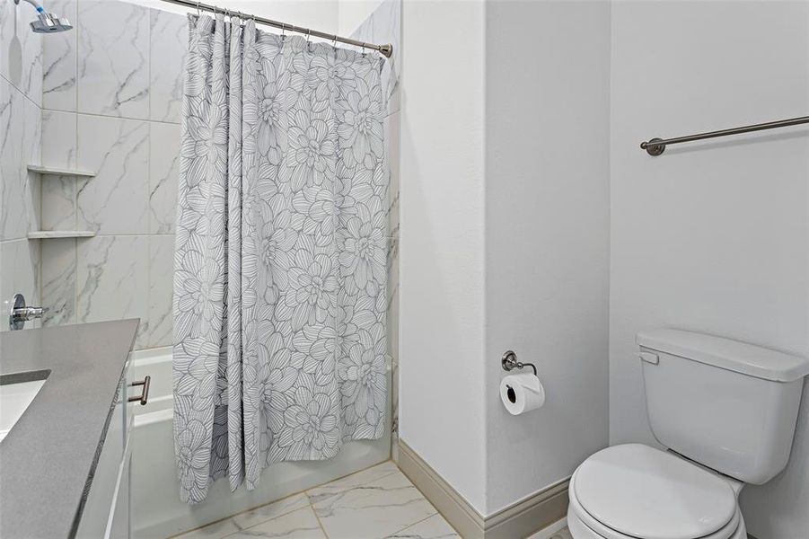 Full bathroom with vanity, toilet, and shower / bathtub combination with curtain