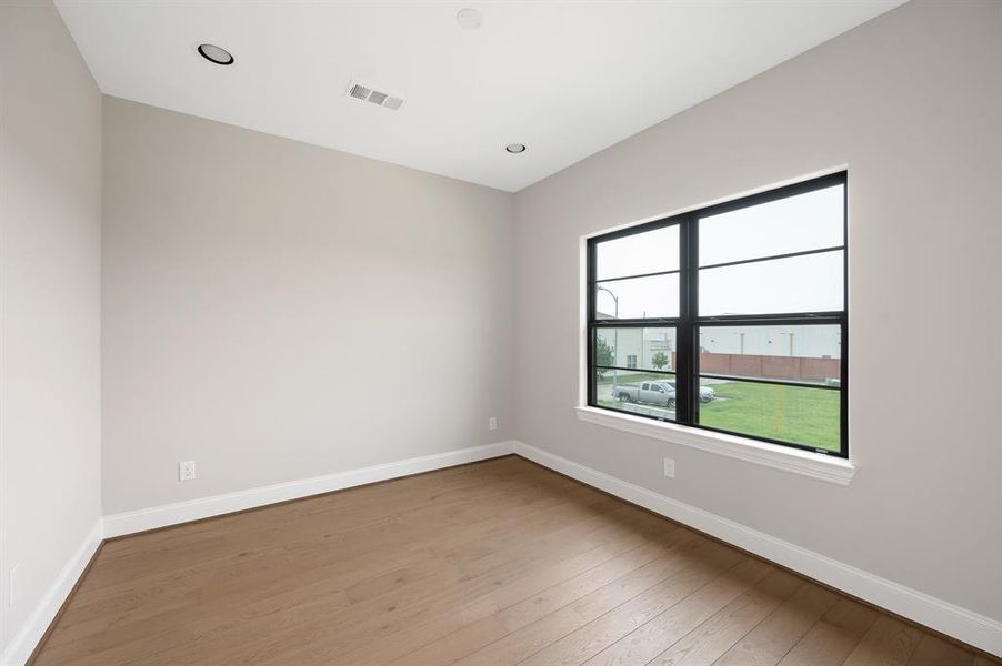 The Home Office/Study/secondary bed room has a large window for plenty of natural light and wood floors