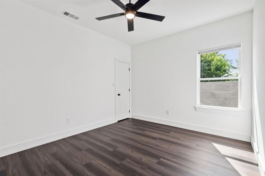 Unfurnished room with dark wood-type flooring and ceiling fan