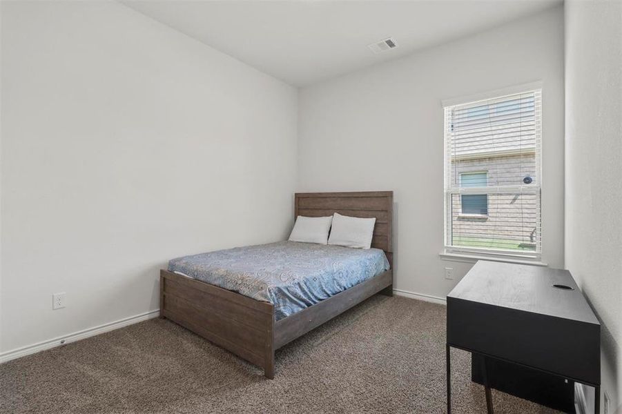 Bedroom featuring carpet flooring and multiple windows