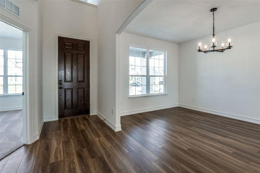 Foyer with dark hardwood / wood-style floors and a chandelier